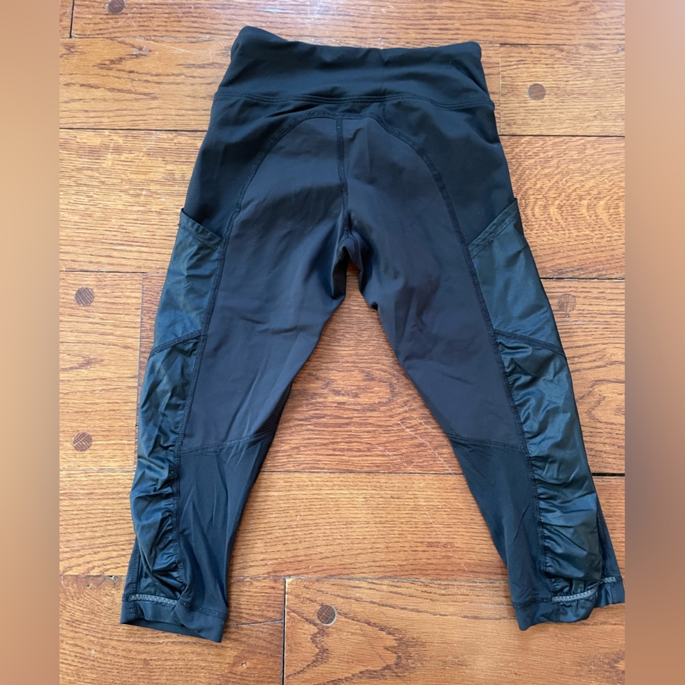 Lululemon black cropped leggings with cargo pockets and pleather detail.